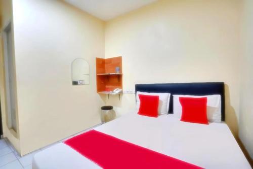 a bedroom with a white bed with red pillows at d Ritz residence in Surabaya