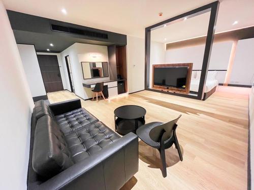 a living room with a couch and a television at 9D City & 9D Express Hotel in Udon Thani