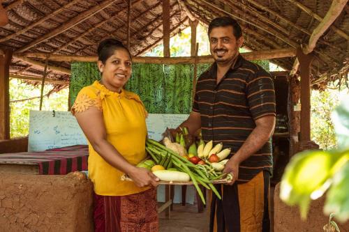 a man and a woman holding a tray of vegetables at Sigiri Aliya Tree house in Sigiriya