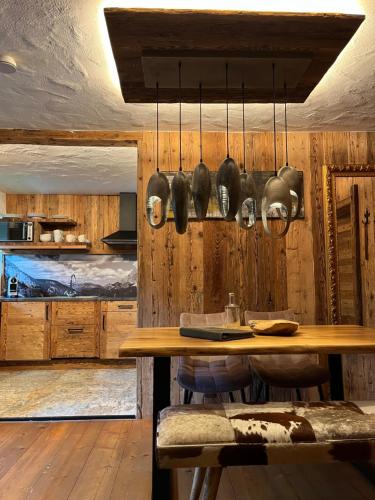 a kitchen with a wooden wall with a table and utensils at Chalet Apart Hansler in Ehrwald