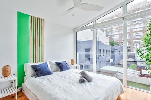 a bedroom with a white bed and a large window at Astounding 3 Bedroom House Surry Hills 2 E-Bikes Included in Sydney