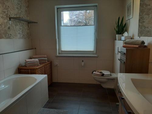 a bathroom with a tub and a toilet and a window at MV Idyll in Dahmen
