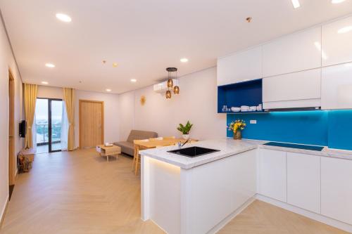 a kitchen with white cabinets and a dining room at Aria Vũng tàu in Vung Tau