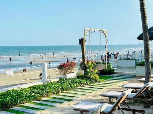 a beach with a swing and people on the beach at Aria Vũng tàu in Vung Tau