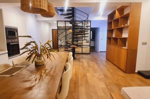 a dining room with a table and a spiral staircase at Duplex avec Rooftop a la Marsa in La Marsa