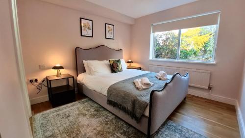 a bedroom with a large bed and a window at Lady Jane Court by Paymán Club in Trumpington