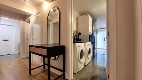 a laundry room with a washer and dryer at Lady Jane Court by Paymán Club in Trumpington
