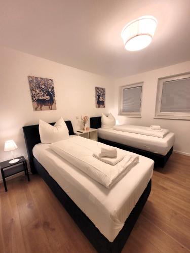 1 Schlafzimmer mit 2 Betten und 1 Zimmer mit 2 Fenstern in der Unterkunft Winterberg Appartement 21126 in Winterberg