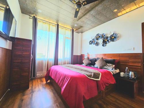 a bedroom with a bed with a red blanket at THE TULIP BIR in Bīr