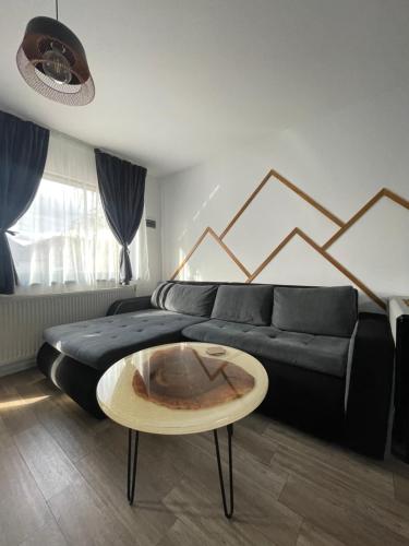 a living room with a couch and a coffee table at NOIA Caban in Piatra Neamţ