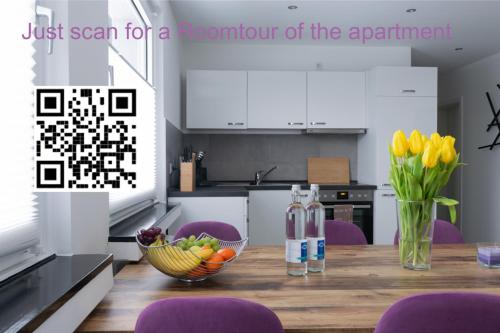 a kitchen with a table with a bowl of fruit and flowers at Designer-Apartment near Düsseldorf+Cologne (Apt.3) in Neuss