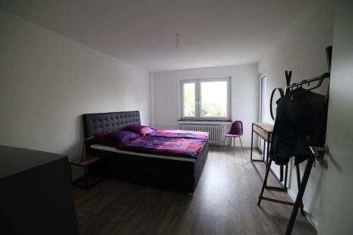 Schlafzimmer mit einem Bett, einem Schreibtisch und einer Kamera in der Unterkunft Designer-Apartment near Düsseldorf+Cologne (Apt.3) in Neuss