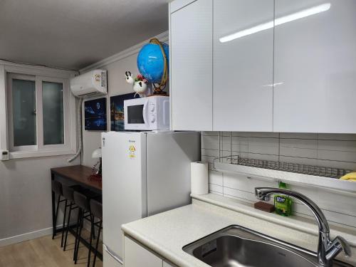 a kitchen with a sink and a white refrigerator at Brand New 2 Bedroom Apartment in Seoul