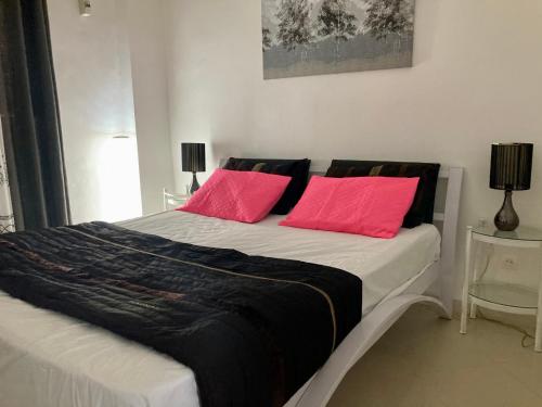 - une chambre avec un lit et 2 oreillers roses dans l'établissement Confortables location familiale vue sur mer à Sidj Fredj, à Staoueli
