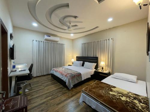 a hotel room with two beds and a ceiling at Alpha Guest House in Rawalpindi