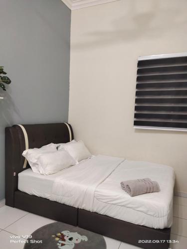 una camera da letto con un letto con lenzuola bianche e una finestra di Homestay Mewah Lumut a Lumut
