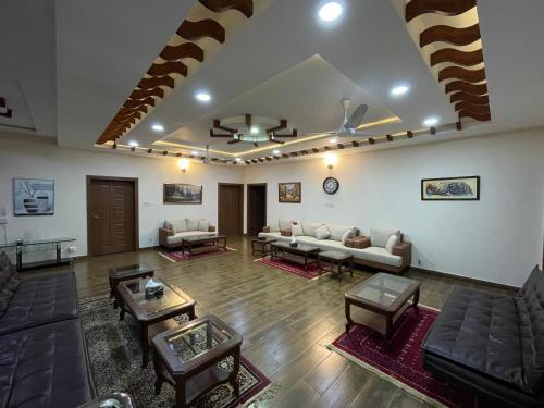 a large living room with couches and tables at Alpha Guest House in Rawalpindi