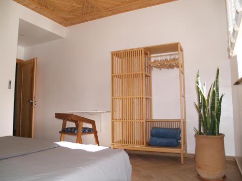 a bedroom with a bed and a mirror and a table at Dar Makai Surf Hotel in Tamraght Ouzdar