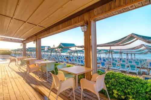 a patio with tables and chairs and the ocean at SUN HEAVEN FAMILY & SPA in Alanya