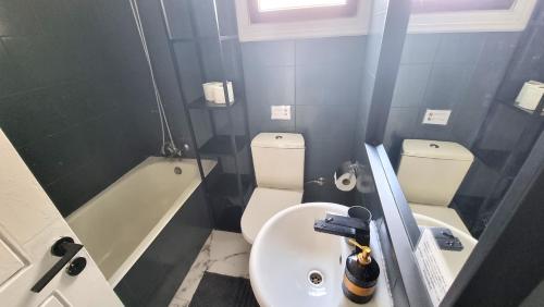 Baño pequeño con aseo y lavamanos en Cozy Beach Apt / Near Airport + 100Mbit internet + Netflix, en Lárnaca