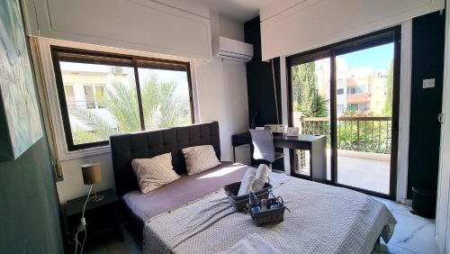 a bedroom with a bed and a large window at Cozy Beach Apt / Near Airport + 100Mbit internet + Netflix in Larnaka