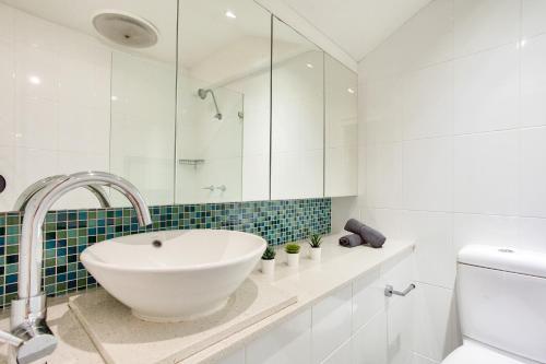 Baño blanco con lavabo y aseo en City Center 2 Bedroom House Pyrmont 2 E-Bikes Included en Sídney