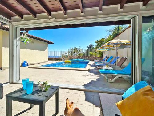 a dog sitting on a patio with a view of a swimming pool at Villa Regina Bella in Balchik