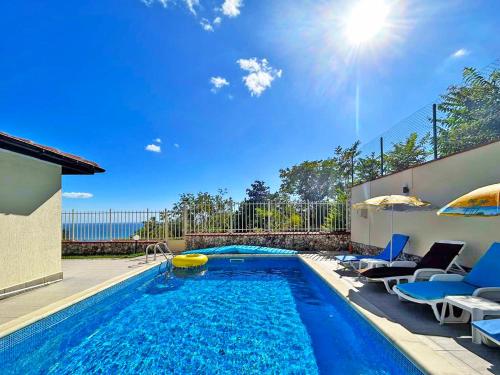 a swimming pool with blue chairs and a swimming pool at Villa Regina Bella in Balchik