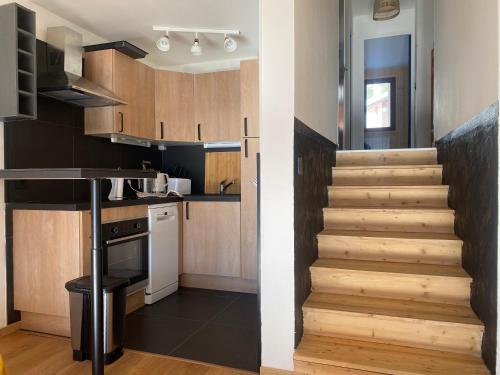 une cuisine avec un escalier menant à une cuisine dans l'établissement Beau duplex refait à neuf, 45m2, 4/5 pers, vue, à Montgenèvre