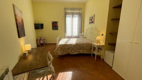 Habitación pequeña con cama y escritorio. en La Contessa B&B Palazzo Plantulli, en Avellino