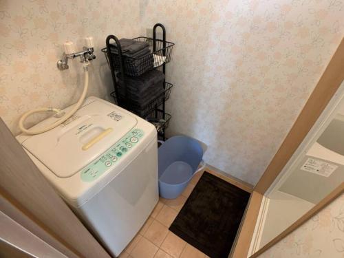 a small bathroom with a washing machine and a sink at 新三条Home 402 in Asahikawa
