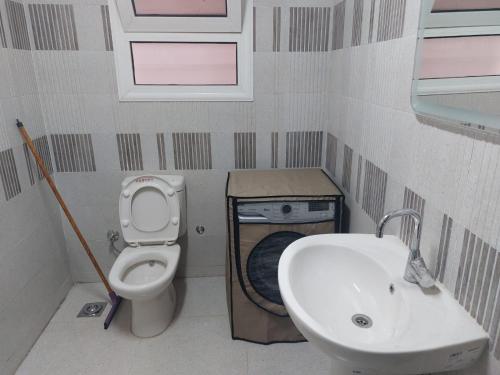 La petite salle de bains est pourvue de toilettes et d'un lavabo. dans l'établissement Happy Transit, au Caire