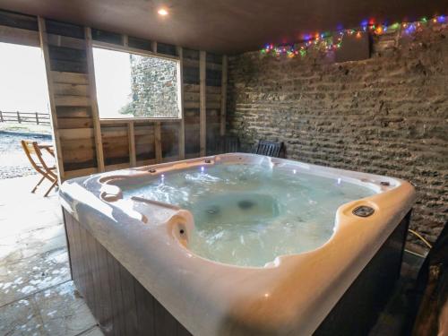 a bath tub in a room with a brick wall at Hawthorn Cottage in Scarborough