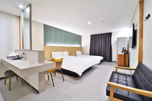 una camera d'albergo con letto e scrivania di Calm Rest Hotel Busan Sasang a Busan