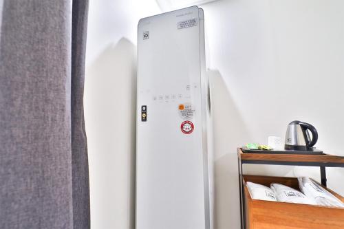 a refrigerator in a room next to a curtain at Calm Rest Hotel Busan Sasang in Busan