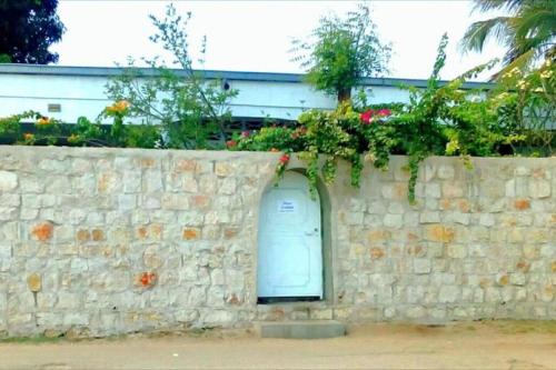 eine Steinmauer mit einer blauen Tür darauf in der Unterkunft La villa flamboyant in Mahajanga