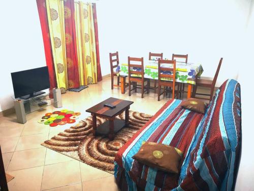 Habitación con cama, mesa y comedor. en La villa flamboyant, en Mahajanga