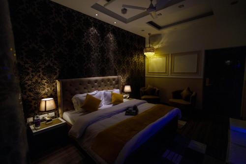 a bedroom with a bed with two lamps and a couch at Victorian Elegance Luxury Stays in Amritsar