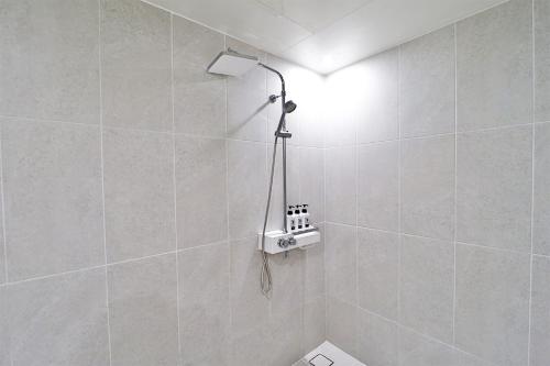 a bathroom with a shower with a light on the wall at Calm Rest Hotel Busan Sasang in Busan