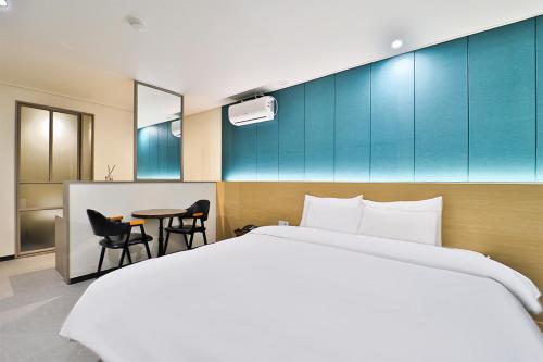 a hotel room with a bed and a table at Calm Rest Hotel Busan Sasang in Busan