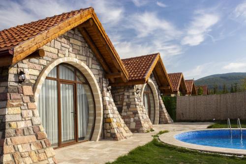 a stone house with a pool and a fence at Amazing Stone House with Private Pool in Iznik in İznik