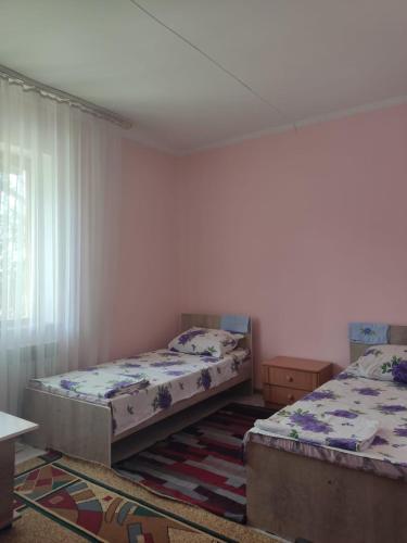 a bedroom with two beds and a window at Азия Hotel in Taraz