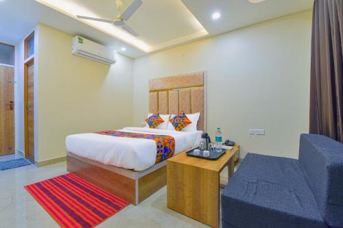 FabHotel Bohra International في جايبور: غرفة نوم بسرير واريكة زرقاء