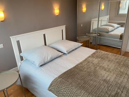 - une chambre avec 2 lits, une table et un miroir dans l'établissement T2 cabine traversant vue front de mer Le Touquet Paris-Plage, à Le Touquet-Paris-Plage