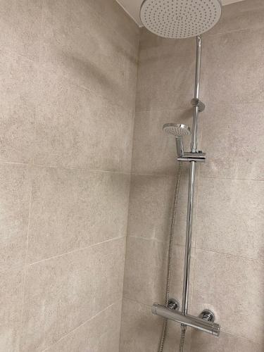 une douche avec pommeau de douche dans une salle de bain dans l'établissement T2 cabine traversant vue front de mer Le Touquet Paris-Plage, à Le Touquet-Paris-Plage