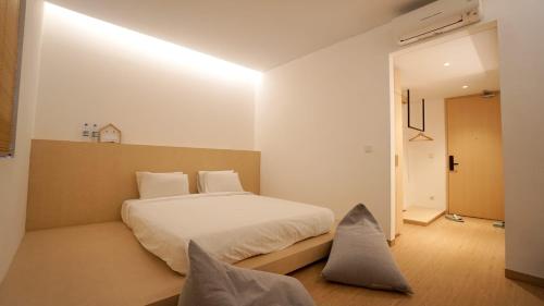 名古屋的住宿－ManukabyHavis Boutique Hotel，卧室配有带枕头的大型白色床