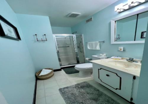 a blue bathroom with a sink and a toilet at One Bed Apartment At UWS in New York