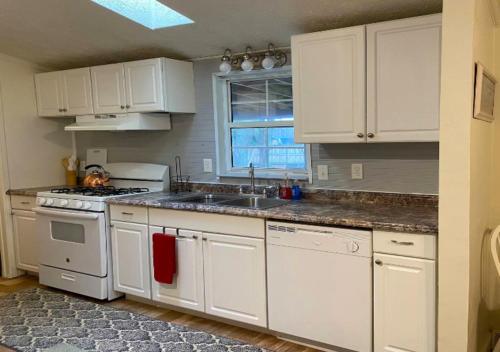 a kitchen with white cabinets and a sink at One Bed Apartment At UWS in New York