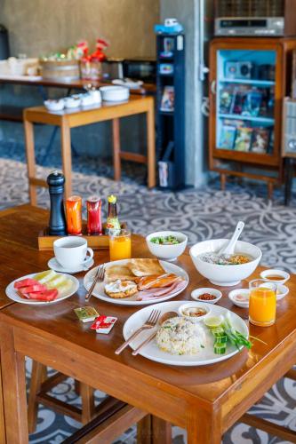 een houten tafel met borden met eten erop bij Vintage54 Hotel Ayutthaya in Phra Nakhon Si Ayutthaya