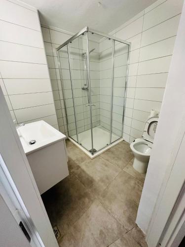 a bathroom with a glass shower and a toilet at St Julian Apartments in St Julian's